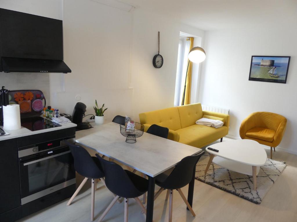 奥雷龙圣皮耶尔Superbe Maison Rénovée en Centre-ville的客厅配有桌子和黄色沙发