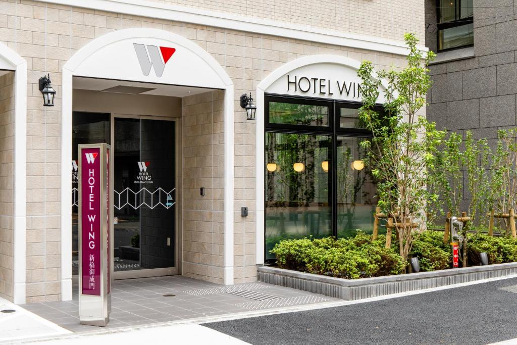 东京Hotel Wing International Shimbashi Onarimon的一家酒店前面的商店,上面有标志