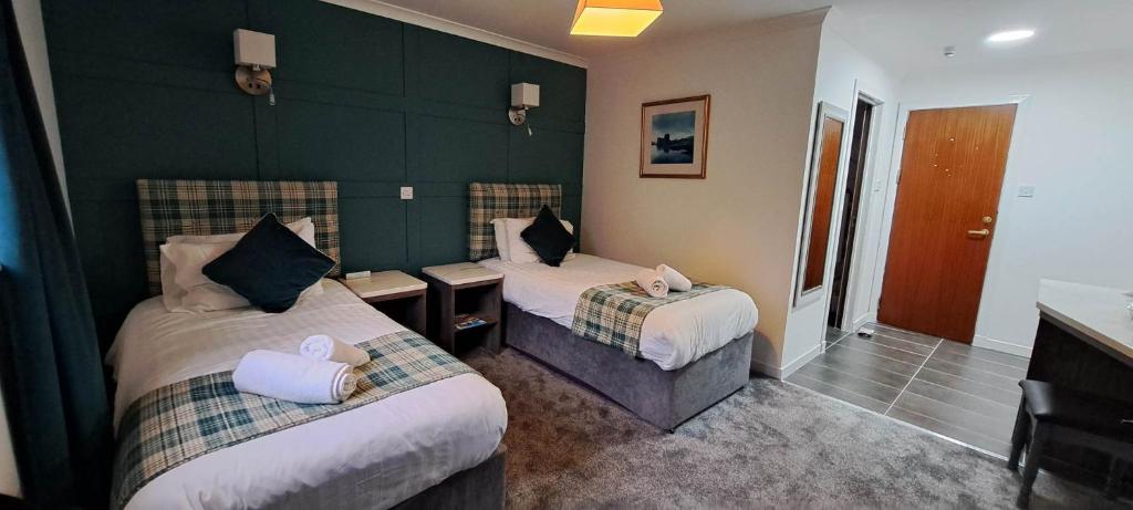 金洛赫利文麦克唐纳酒店及小屋的酒店客房设有两张床和绿色的墙壁。