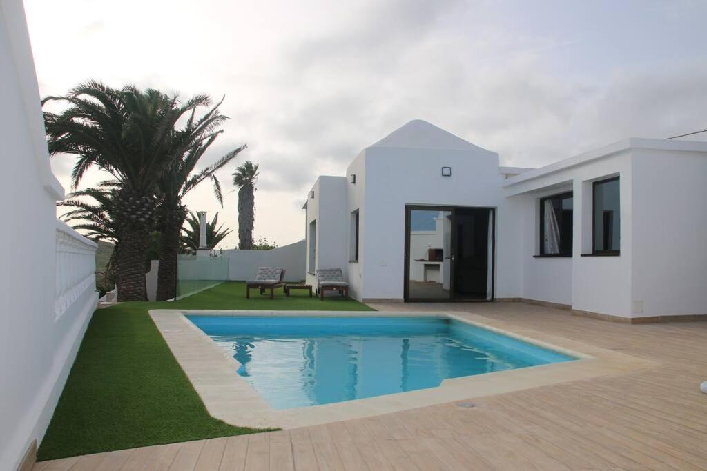 纳萨雷特Villa Darío en Nazaret的一座白色的房子,在庭院里设有一个游泳池