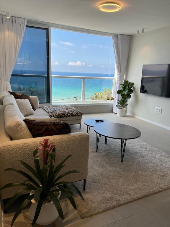 巴特亚姆Vacation Apartment By The Beach的客厅配有沙发和桌子