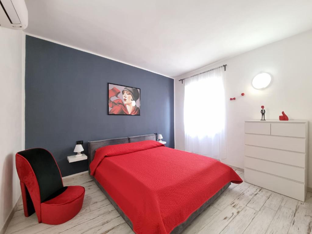 卡波利韦里Solino House的一间卧室配有红色的床和红色椅子