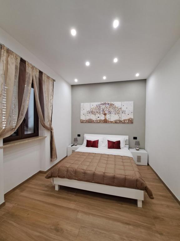 帕尔蒂尼科Colle del Re Sicily的白色卧室配有一张带红色枕头的大床