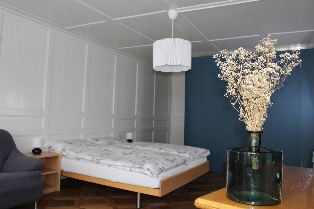 穆尔滕Hotel Jäger的一间卧室,配有一张床,桌子上放着花瓶