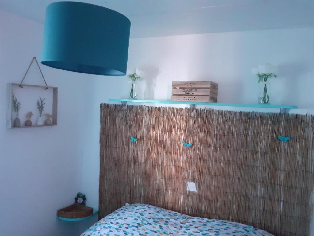 维克拉加尔迪奥勒les cigales的一间卧室配有床头板和蓝灯