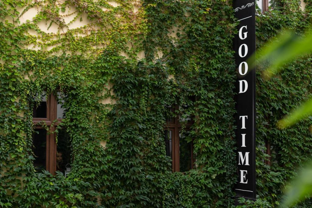 罗兹美好时光公寓式酒店的一座被绿色常春藤覆盖的建筑,设有窗户
