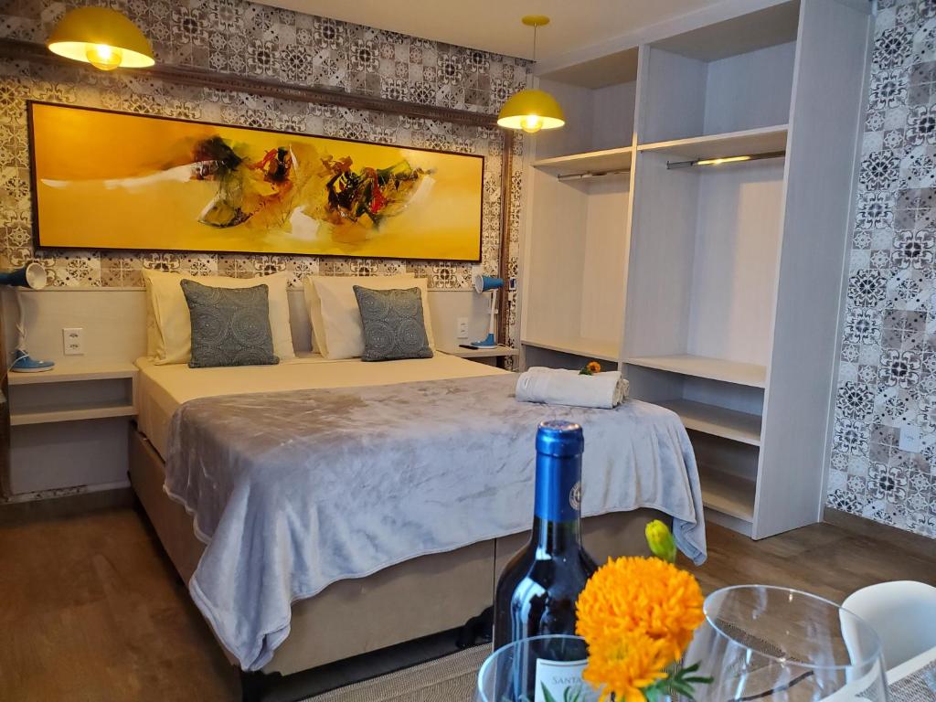 戈亚斯州上帕莱索Villa Terragona的一间卧室配有一张床和一瓶葡萄酒