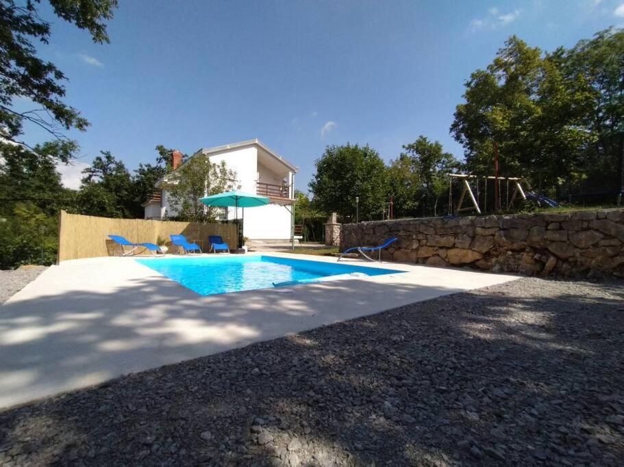 尤尔达尼Holiday home Brgud with private pool near Opatija的房屋前的游泳池