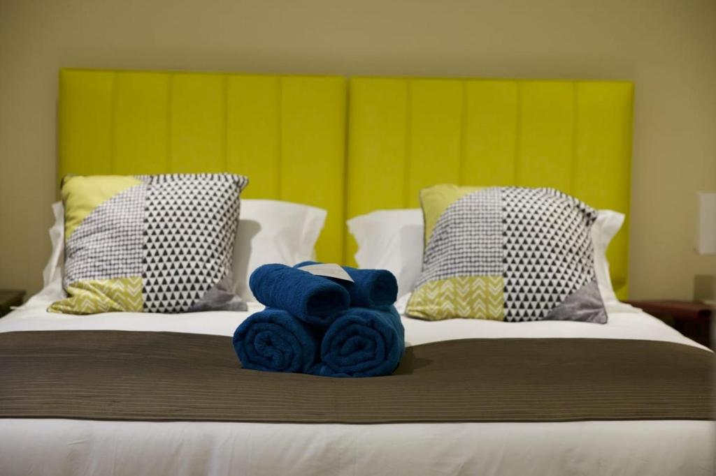 斯坦利Tu Guesthouse的床上方摆放着蓝色毛巾的床