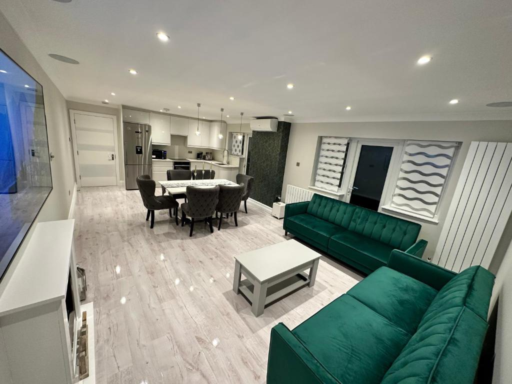 格林福德Luxury House的客厅配有绿色沙发和桌子