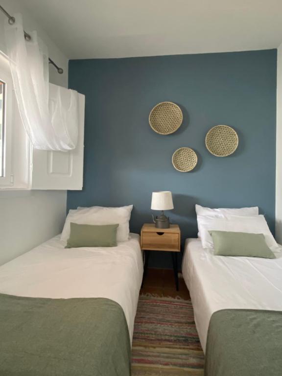 Quinta de CavaleirosA Quinta da Estrelinha的蓝色墙壁客房的两张床
