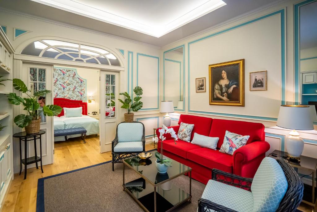 波尔图波尔图大酒店的客厅配有红色的沙发和床。