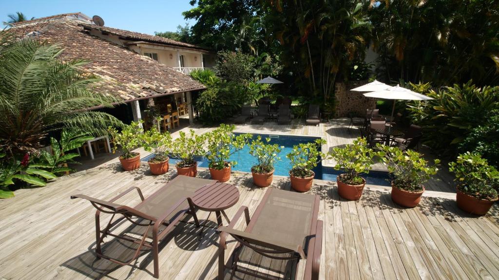 伊利亚贝拉伊利亚戴克酒店的一个带桌椅和植物的庭院和一个游泳池