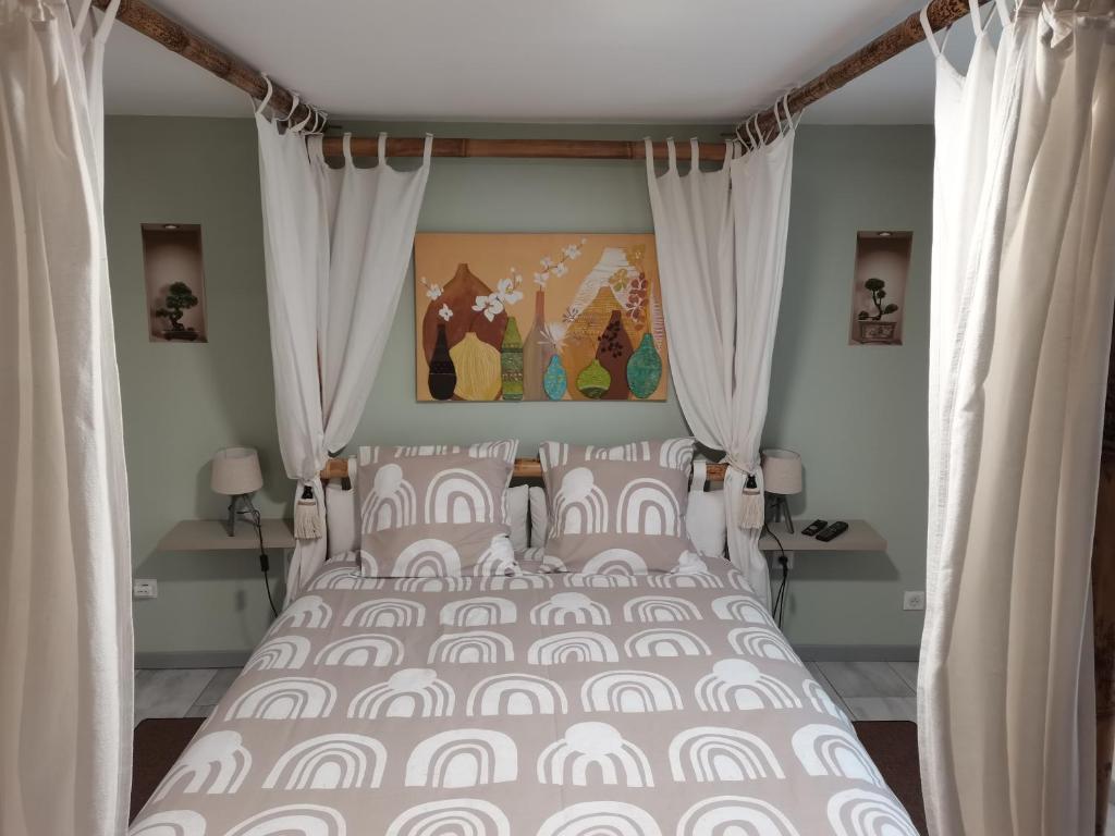CastelsLe clos Le Roc Rouge的卧室配有一张带白色窗帘的大床