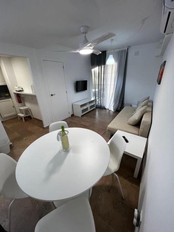 萨洛Apartamento a 3 minutos de la playa的客厅配有白色的桌椅