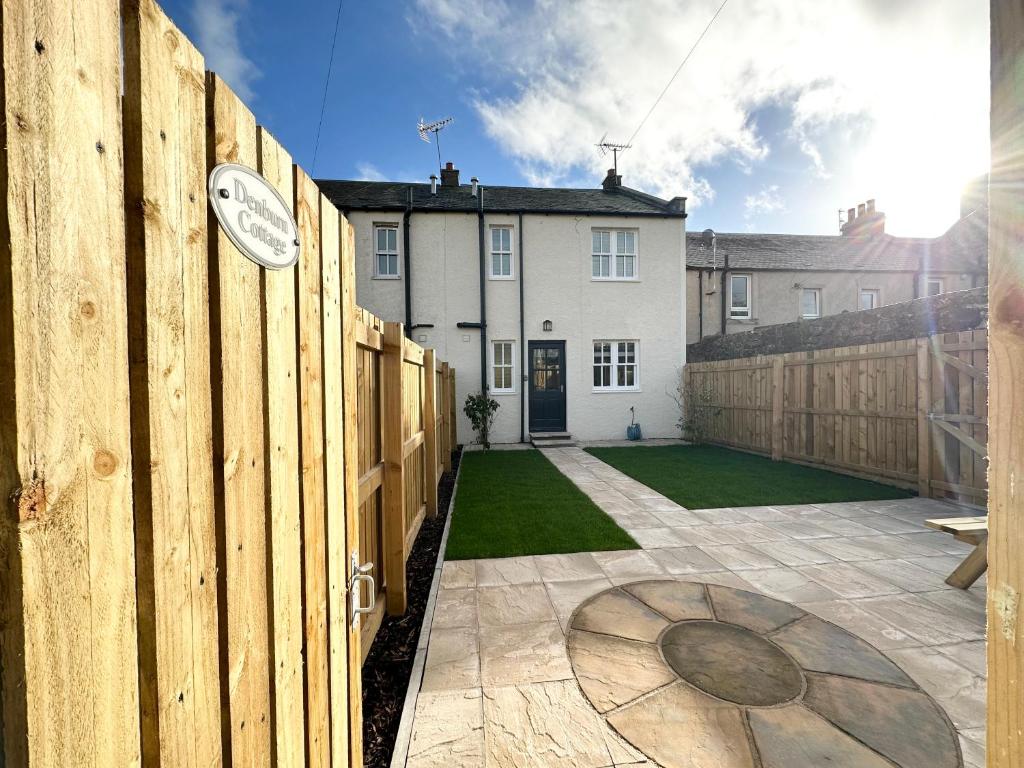 ColinsburghDenburn Cottage, East Neuk of Fife的房屋旁的栅栏上有一个钟