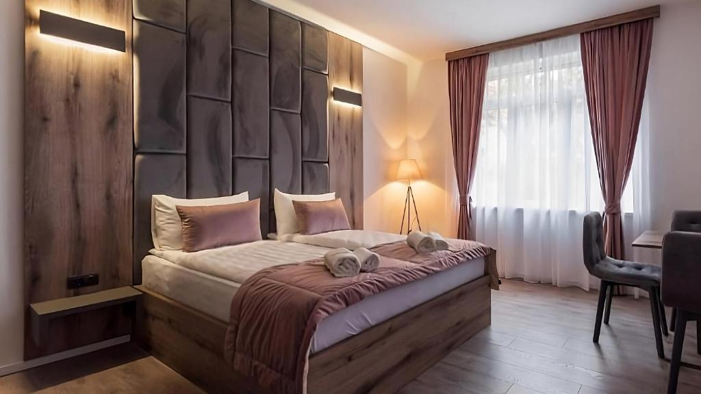 萨拉热窝Casa ARTEE Free Parking的一间卧室配有一张大床和软垫床头板
