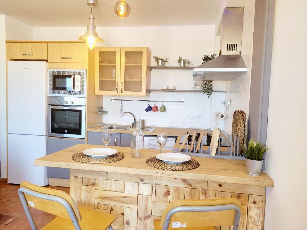 阿里纳加Casa Faro de Arinaga的厨房配有木桌、椅子和水槽
