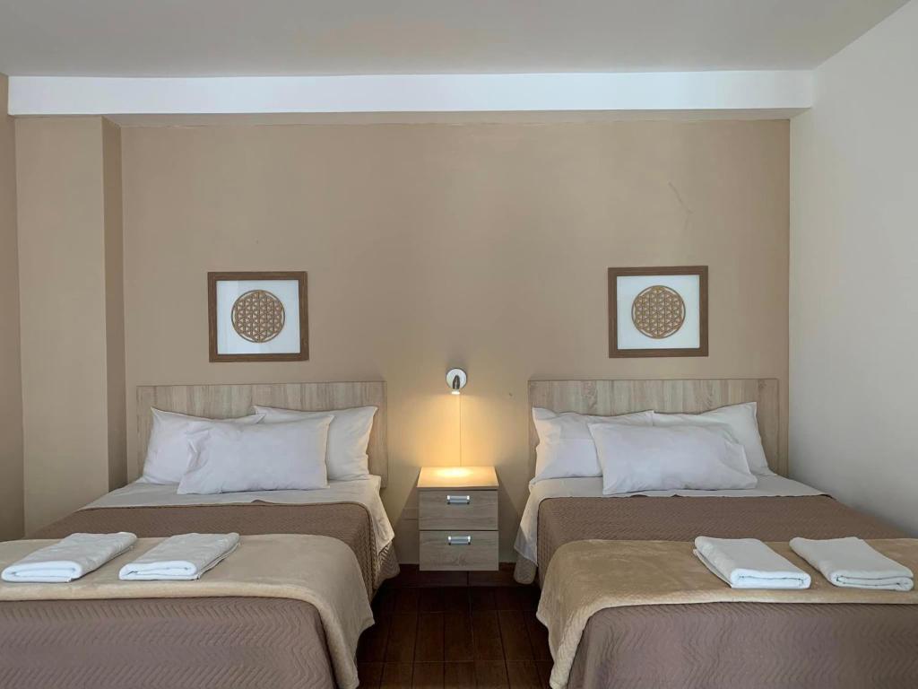 塔克纳Renace Suites的两张位于酒店客房的床,配有毛巾