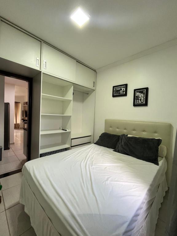 格拉瓦塔Winterville flat 307的卧室配有白色的大床和架子