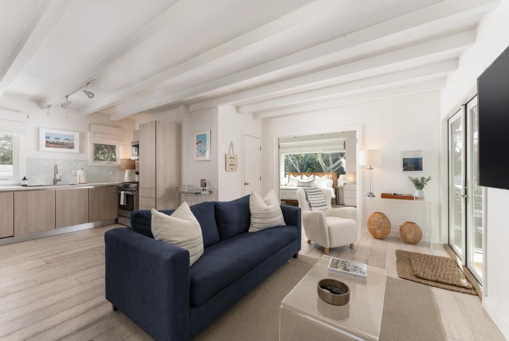 MontecitoPalm Cottage的一间带蓝色沙发的客厅和一间厨房