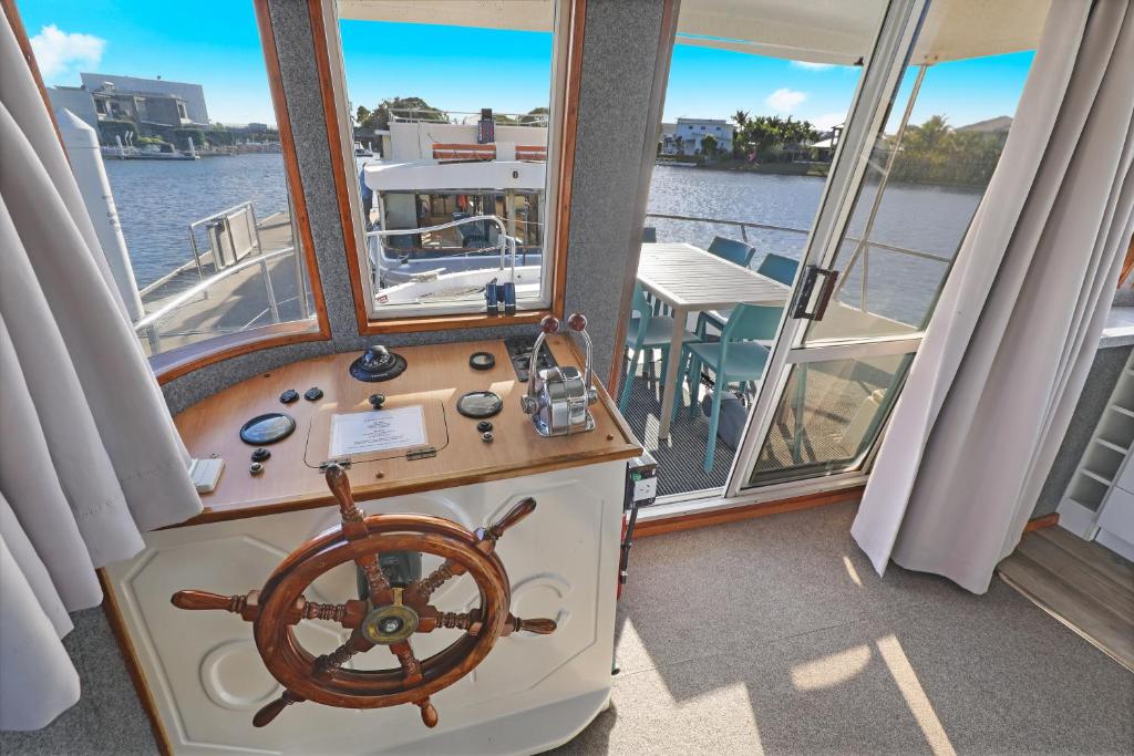 Pelican WatersCaloundra Houseboats的窗户间内有舵轮的船只