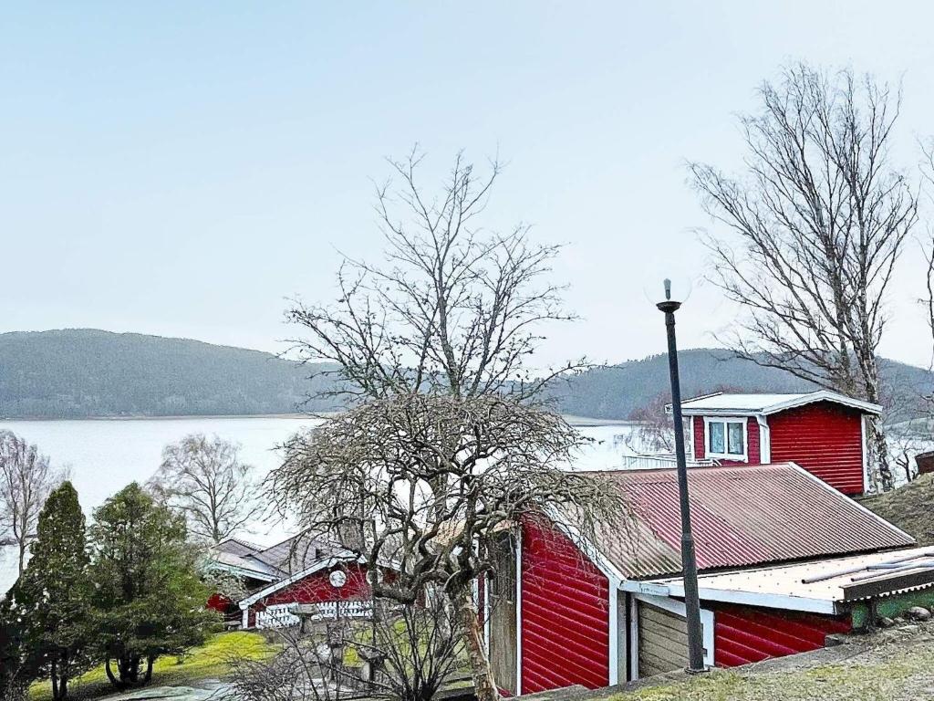 乌德瓦拉Holiday home Uddevalla XXIII的湖畔山丘上的红房子