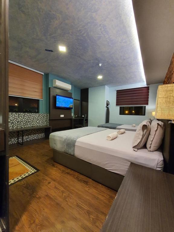 怡保怡保可爱酒店及旅馆的一间卧室配有一张大床和一台平面电视