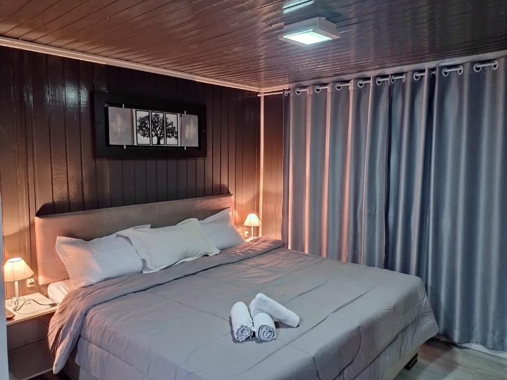 卡内拉Chalé D´Roos III的一间卧室配有一张床,并备有2个拖鞋