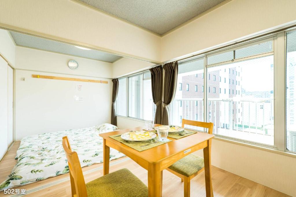 鹿儿岛Nanei Building - Vacation STAY 03606v的客房设有桌子、床和窗户。