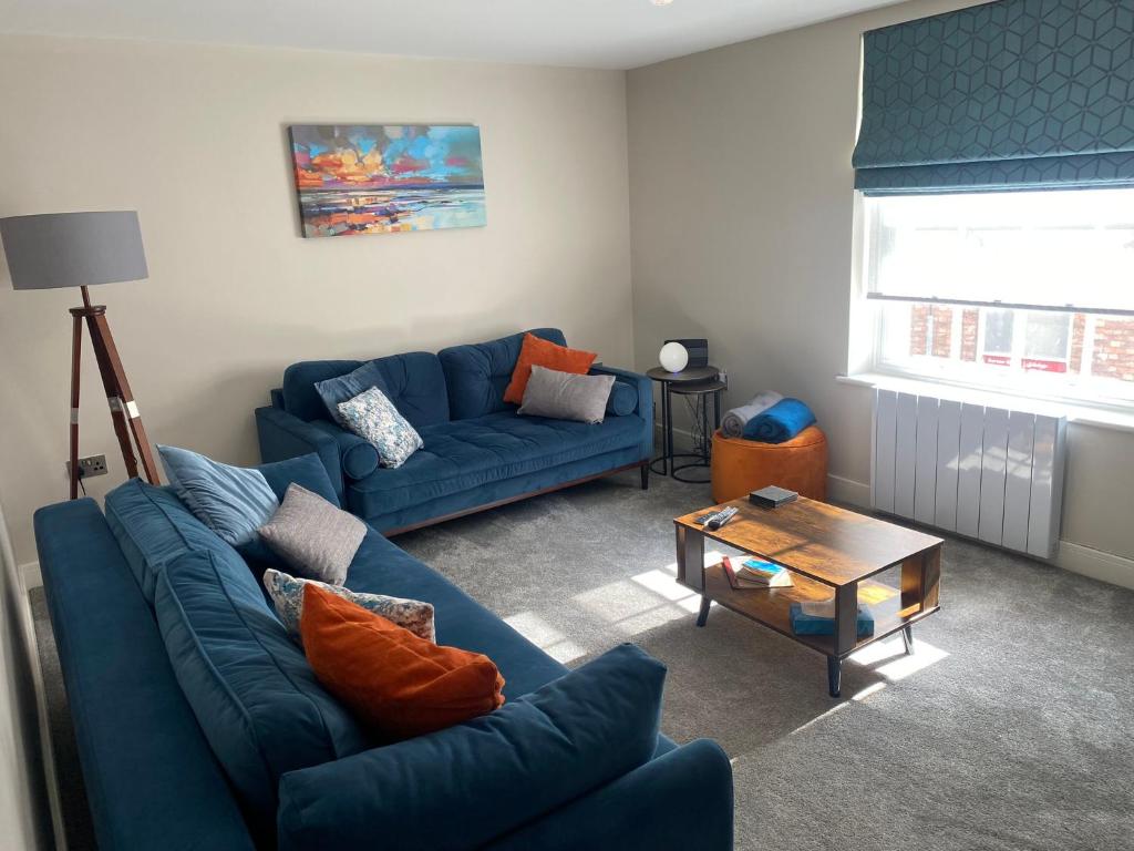 绍斯韦尔RECENTLY RENOVATED property in the heart of Southwell的客厅配有2张蓝色的沙发和1张桌子