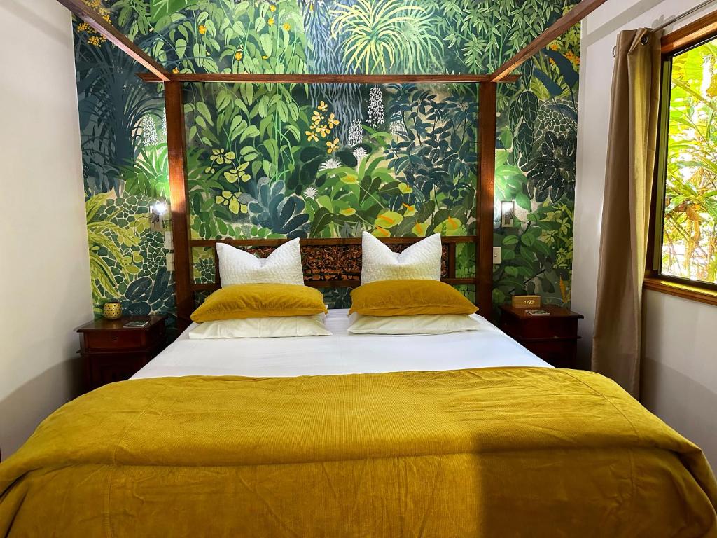 云加布拉火山口湖泊雨林小屋酒店的一间卧室配有一张带黄色床单的大床