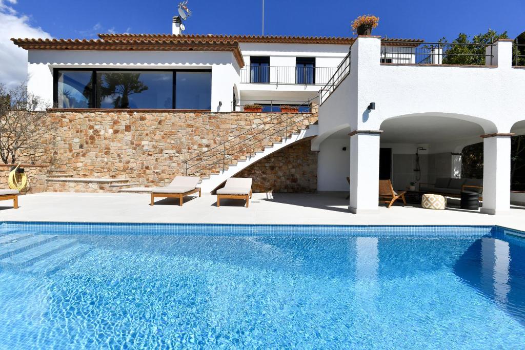 Castillo de AroVilla with seaview at Platja d'Aro 11p的一座带游泳池和房子的别墅