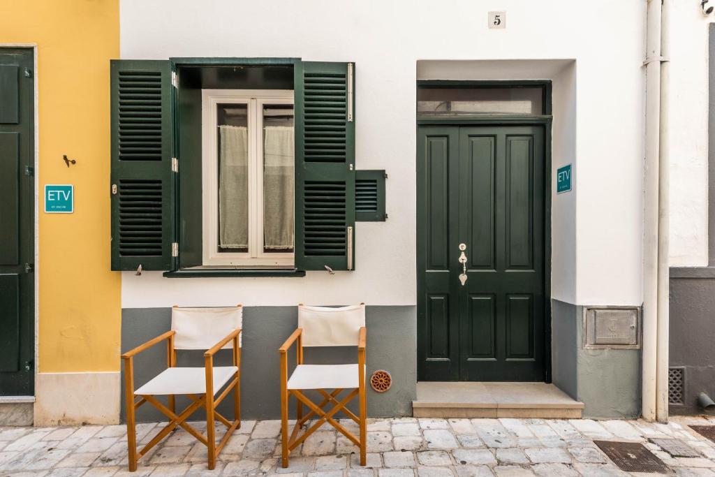 休达德亚Holiday Home Casa Sant Pere by Mauter Villas的两把椅子坐在一座带绿门的建筑前面
