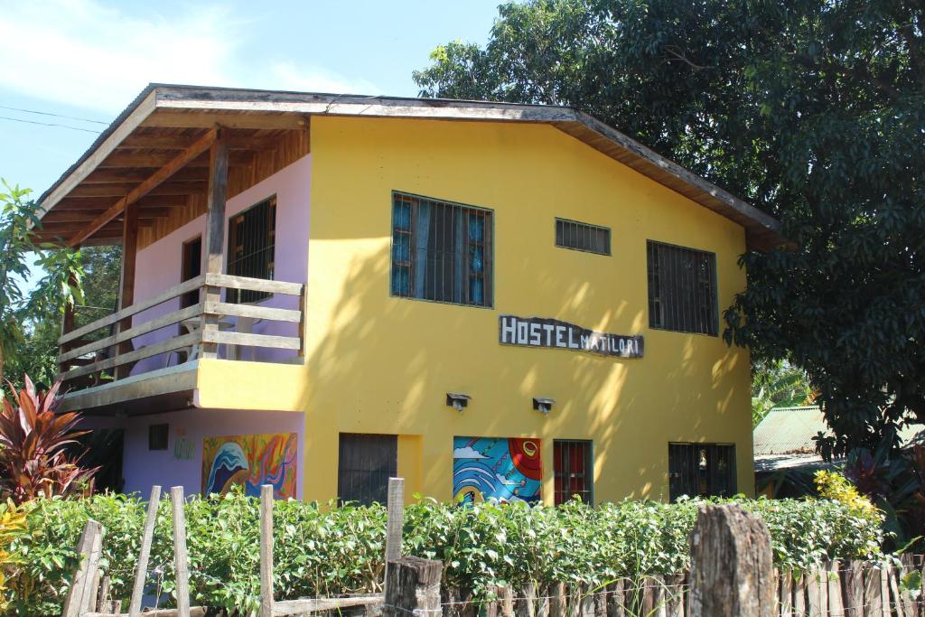萨玛拉Hostel Matilori的前面有栅栏的黄色房子