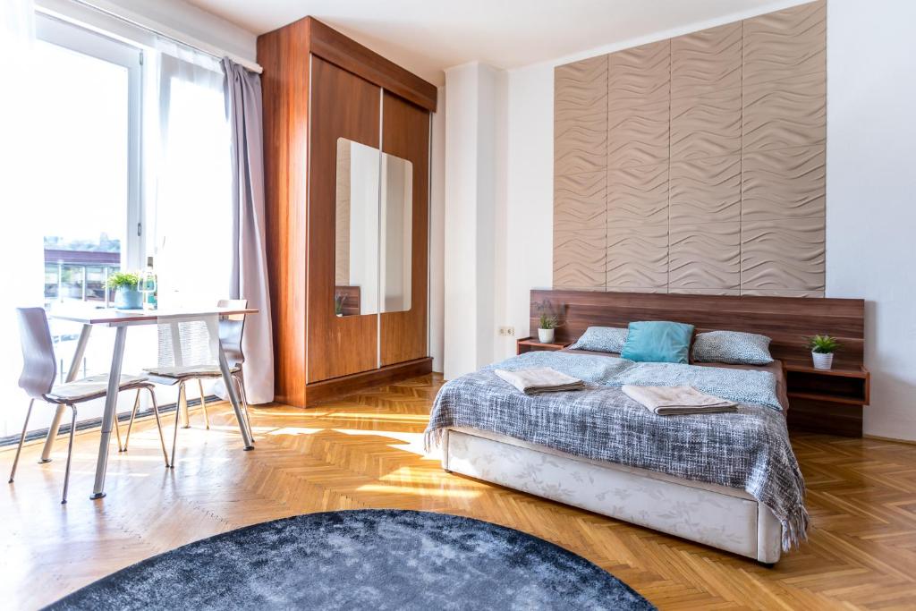 布达佩斯Danube Apartment的一间卧室配有一张床、一张桌子和一张书桌