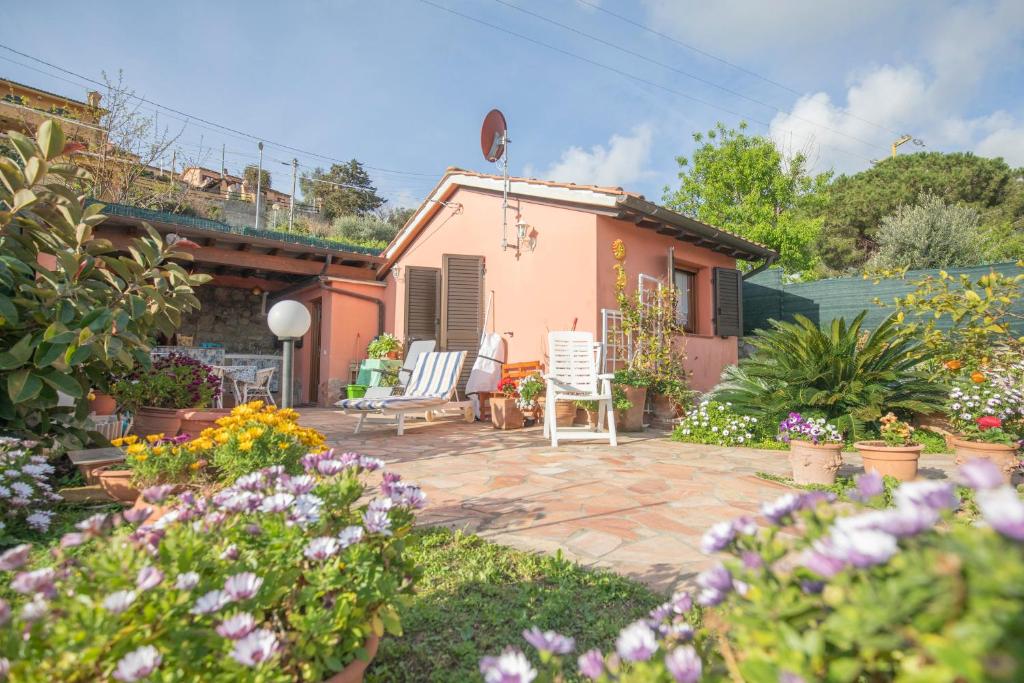 里奥马里纳HelloElba Villetta Fiorita的房屋前方带椅子和鲜花的庭院