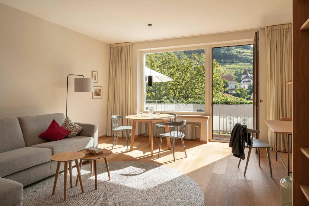 梅拉诺Der Ladurner Hof - Wohnen am Weinberg的客厅配有沙发和桌椅