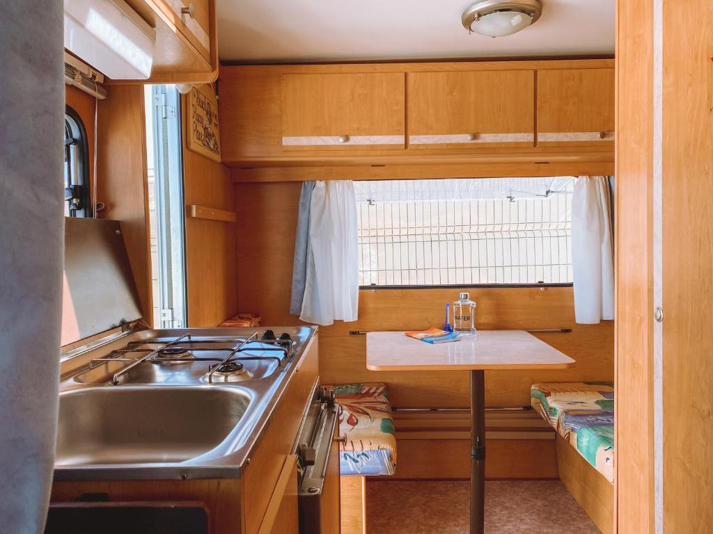 蒂纳霍Glamping Caravan Lanzarote的厨房配有水槽、炉灶和桌子