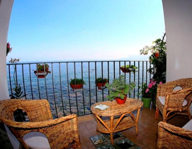 希拉拉维度塔住宿加早餐酒店的一个带桌椅的海景阳台