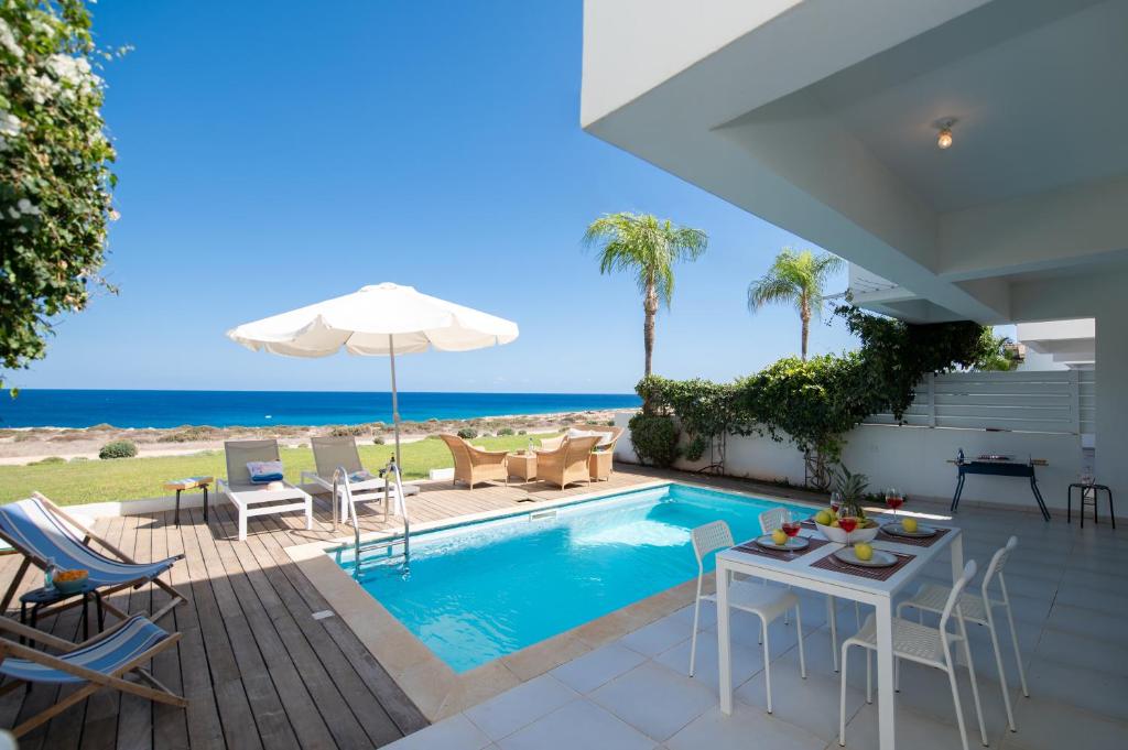 普罗塔拉斯Jasmine Sea Front Villa的一座带游泳池和大海的别墅