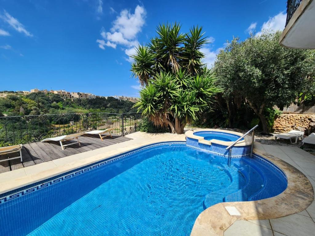 Għajn il-KbiraExclusive Pool with your own views with 3 bedrooms and 4 bathrooms in Gozo的一座树木繁茂的庭院内的游泳池