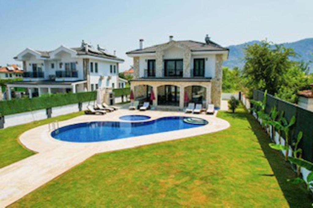 达利安Stunning 4 bedrooms Luxury Villa Kaan Dalyan的一座大房子,在庭院里设有一个游泳池