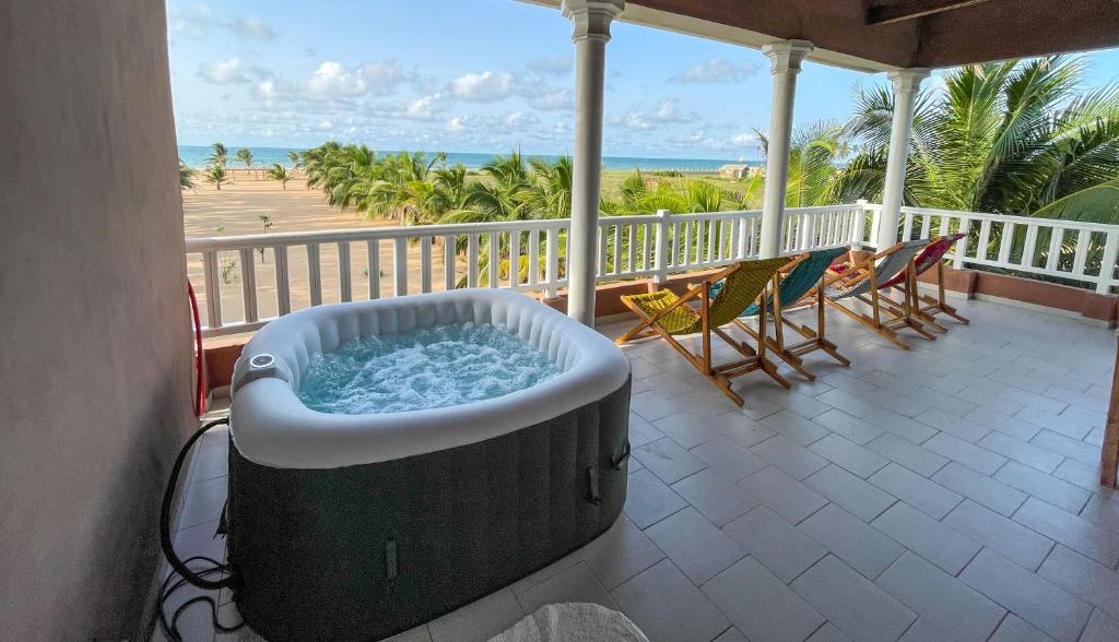 Grand-PopoSpacious and cozy beachfront villa的海滩景阳台的热水浴池