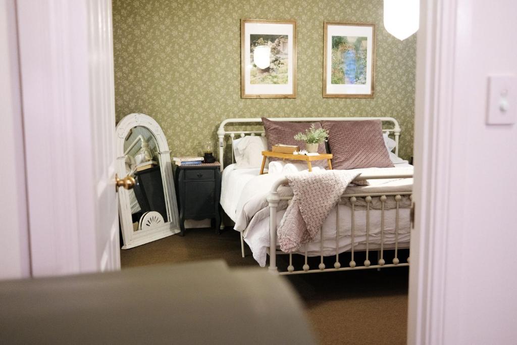 谭伯连山Enchanting Retreat - The English Cottage at Tamborine Mountain的一间卧室配有一张床和镜子