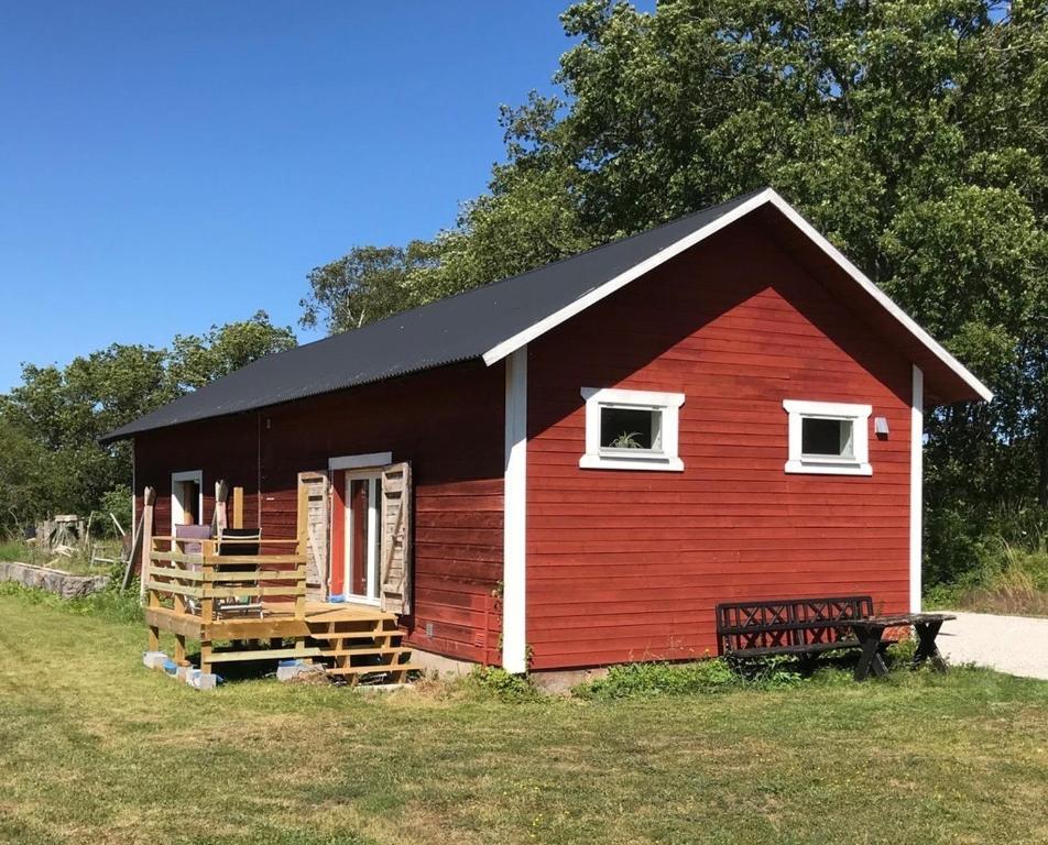BurgsvikTågmagasinet Fidenäs的一间黑色屋顶的红色小房子