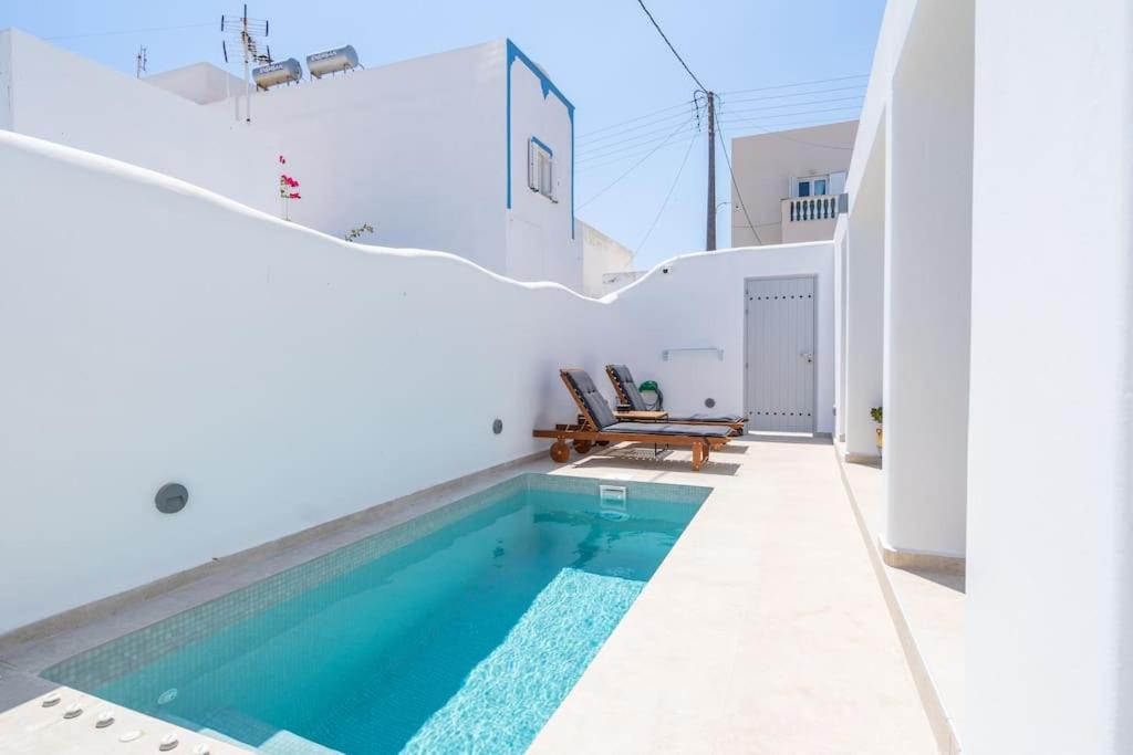 卡特瑞杜斯Acrus Villa Santorini with Heated pool的房屋中间的游泳池