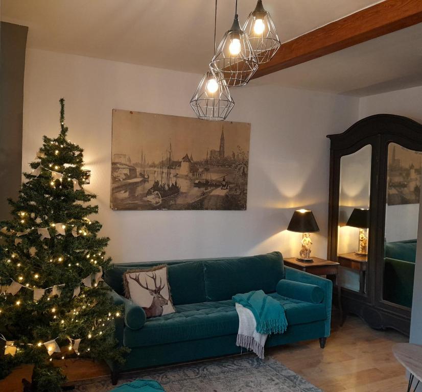 贝格海姆Gîte Le3 Bergheim的客厅配有绿色沙发和圣诞树