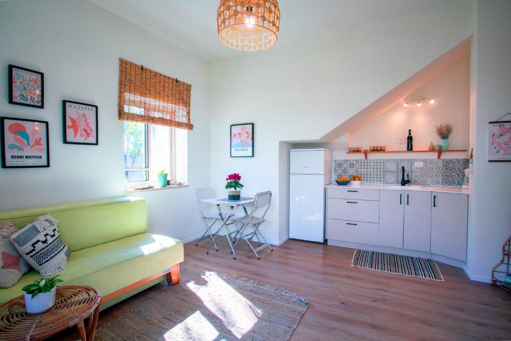 哈德拉lotus beach house的一间带绿色沙发的客厅和一间厨房
