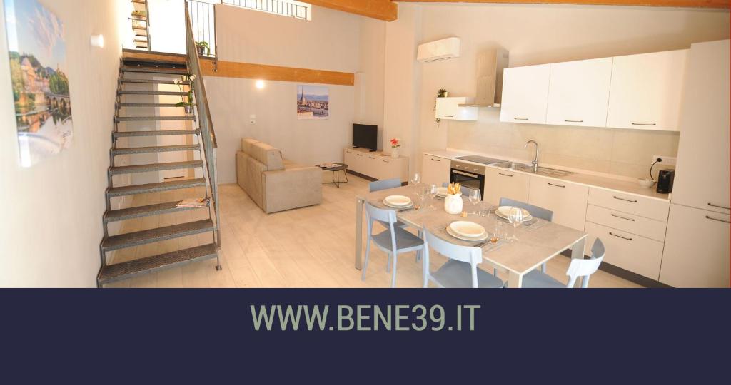 都灵Bene39的厨房以及带桌子和楼梯的用餐室。